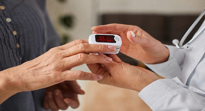 Oxygen saturation being measured with a fingertip pulse oximeter by a healthcare professional